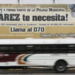 A bus passes a recruiting billboard for the municipal police that reads in Spanish "Juarez Needs You! Join up and become part of the city police" in Ciudad Juarez, Mexico, Thursday. After police recruitment fell in the wake of drug cartel's attacks which killed seven police commanders, government officials erected enormous recruitment billboards.
